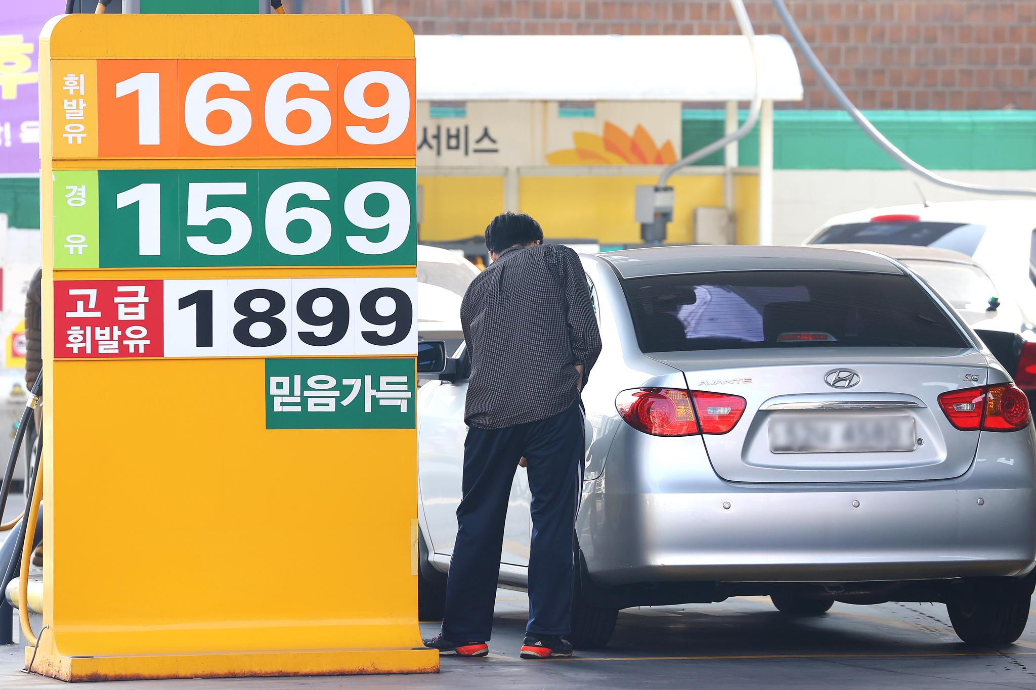 A driver fills up on gas at a gas station in Seoul on March 9. [YONHAP]
