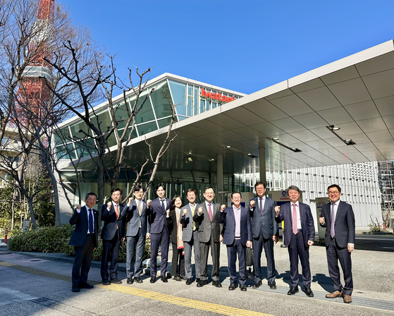 Hyundai Motor Executive Vice President Lee Hang-soo, second form left, and People Power Party Rep. and Korea-Japan Parliamentarians’ Union Chair Ju Ho-young, seventh from left, pose for a photo outside a hydrogen charging station near Tokyo Tower in Tokyo. [KOREA-JAPAN PARLIAMENTARIANS' UNION]