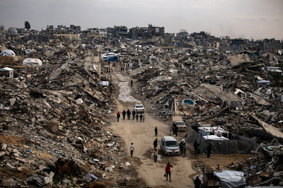Palestinians walk among the rubble of their destroyed homes during the month of Ramadan, in the city of Beit Lahia, northern Gaza Strip, on March 9. [EPA/YONHAP]