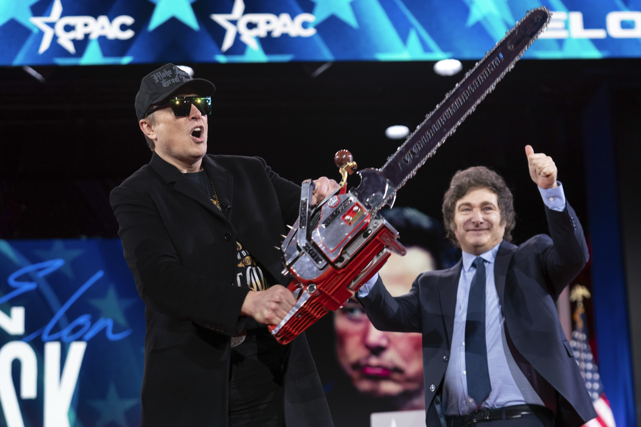 Elon Musk holds up a chainsaw he received from Argentina's President Javier Milei, right, as they arrive to speak at the Conservative Political Action Conference, CPAC, at the Gaylord National Resort & Convention Center, Thursday, Feb. 20, in Oxon Hill, Md. [AP/YONHAP]
