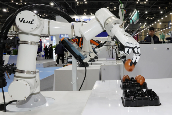 A robotic arm manipulates an egg at Intermold Korea 2025 at Kintex in Goyang, Gyeonggi, on March 11. [YONHAP]