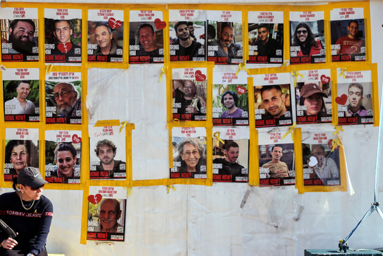 A woman sits at a public square, dedicated to hostages, where pictures and memorabilia of hostages, kidnapped during the deadly Oct. 7, 2023 attack on Israel, are displayed in Tel Aviv, Israel, on March 11. [REUTERS/YONHAP]