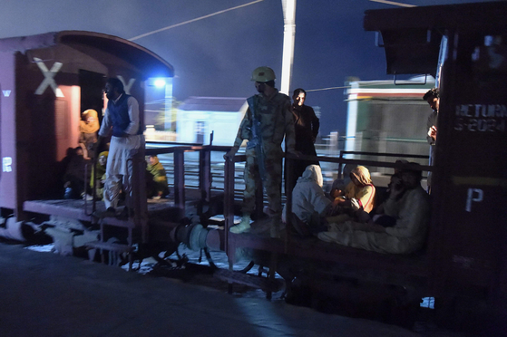 A soldier works to evacuate freed train passengers at the Mach railway station, which has been turned into a makeshift hospital, after Pakistani security forces freed nearly 80 passengers following a security operation against armed militants who ambushed the train in the remote mountainous area, in Mach, southwestern Balochistan province on March 11. [AFP/YONHAP]