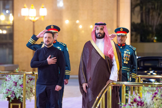 Saudi Crown Prince Mohammed bin Salman, right, accompanying Ukraine's President Volodymyr Zelensky during a guard of honor at the Royal Palace in Jeddah on March 10, 2025. Ukraine will present the United States on March 11 with a plan for a partial ceasefire with Russia, hoping to restore support from its key benefactor, which under President Donald Trump has demanded concessions to end the three-year war. [AFP/SPA/YONHAP] 