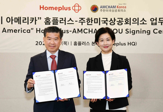 James Kim, chairman and CEO of the American Chamber of Commerce in Korea, left, and Jo Ju-yeon, CEO of Homeplus, take a commemorative photo at the "Buy America" Homeplus-Amcham MOU Signing Ceremony at Homeplus' headquarters in Gangseo District, western Seoul, on March 13. [HOMEPLUS]