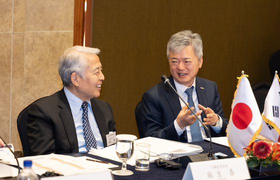 Lee In-ho, executive vice chairman of the Korea International Trade Association, right, and Yutaka Aso, chairman of Aso Cement, discuss potential economic cooperation at the Korea-Japan New Industrial Trade Conference in Lotte Hotel in central Seoul on March 13. [KITA]