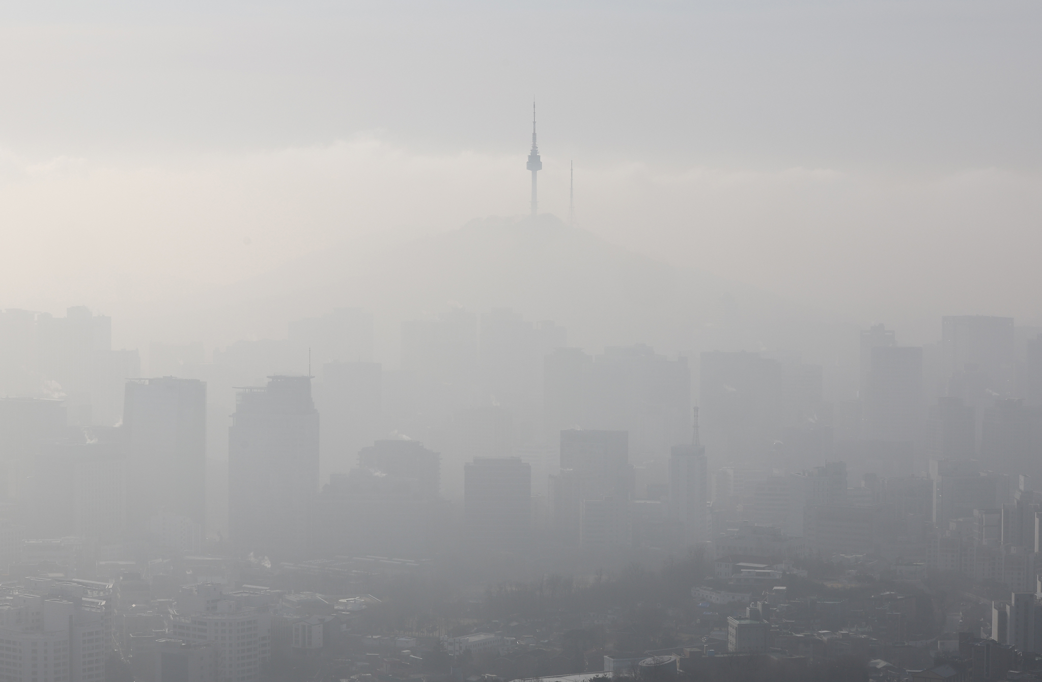 N Seoul Tower, a landmark Seoul building with a transmission antenna sitting atop Namsan, is seen above the city enveloped in a yellow haze as the fine dust concentration reached “bad” — the third highest level in a four-tier system — on March 13. The photo was taken from Mount Inwang in Jongno District, central Seoul.[YONHAP]
