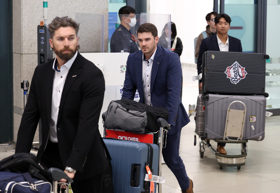 Doosan Bears Jake Cave, left, returns home through Incheon International Airport on March 4 after completing 36 days of training in Japan. [NEWS1] 