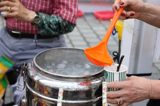 A cup of iced coffee is being made at an outside booth in Daejeon in June 2024. [YONHAP] 