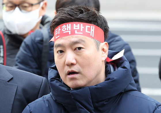Kim Se-ui of YouTube channel Hoverlab wears a headband reading "Against impeachment" at a press conference on March 17 in front of the Seoul Metropolitan Police Agency in central Seoul, held by late actor Kim Sae-ron's family's attorney Bu Ji-seok, before filing a report against YouTuber Lee Jin-ho of defamation. [YONHAP]