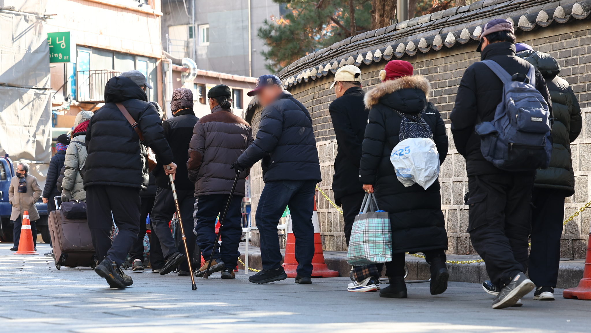 Senior citizens wait to receive food at the Wongaksa soup kitchen near Tapgol Park in Jongno District, central Seoul, on Dec. 24, 2024. Korea became a ″super-aged society,″ classified by the United Nations as when the population aged 65 years or older account for more than 20 percent of the total population, as of Dec. 23, 2024. [YONHAP] 