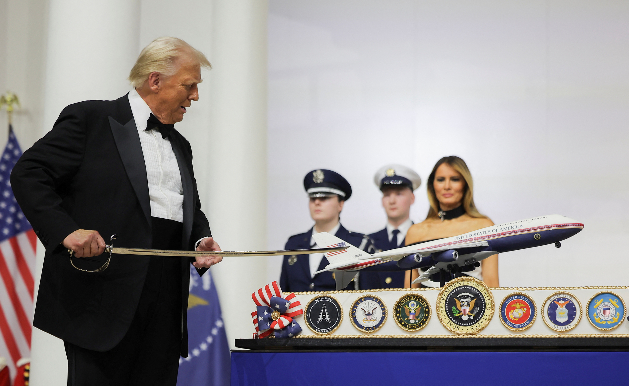 President Donald Trump cuts a cake with a sword during the Commander in Chief Ball in honor of the inauguration of President Donald Trump in Washington, U.S., Jan. 20. [REUTERS/YONHAP]