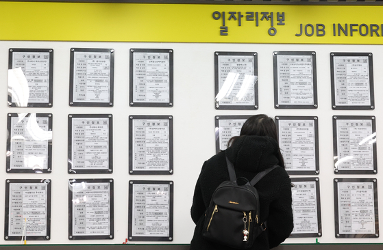 A job seeker looks at postings at an employment and welfare center in Mapo District, western Seoul, on March 17. [YONHAP]