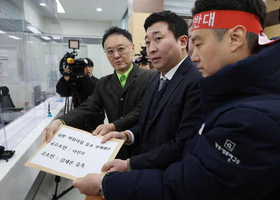 Attorney Bu Ji-seok, center, and YouTuber Kim Se-ui of channel Hoverlab, right, hands in the complaint against YouTuber Lee Jin-ho to the Seoul Metropolitan Police Agency in central Seoul on March 17. [YONHAP]