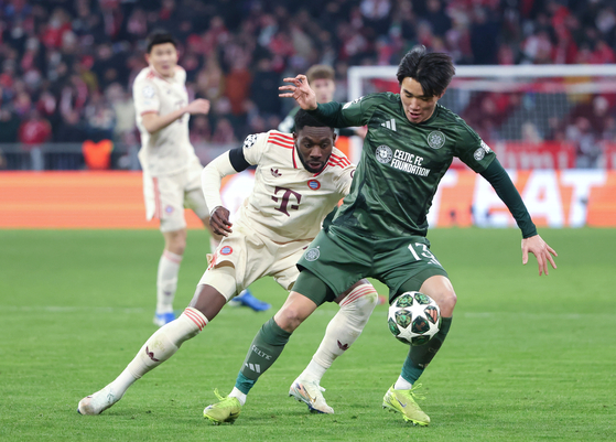 Alphonso Davies of Bayern Munich, left, vies with Yang Hyun-Jun of Celtic during a UEFA Champions League knockout phase play-off second leg football match in Munich, Germany on Feb. 18. [XINHUA/YONHAP]