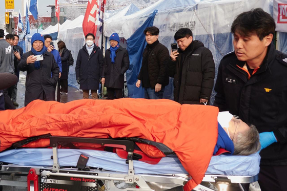 Liberal Democratic Party Rep. Min Hyung-bae is transported by paramedics to a hospital during his hunger strike calling for an impeachment of President Yoon Suk Yeol. [YONHAP] 