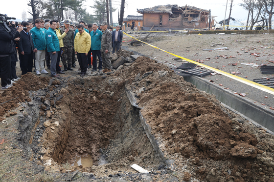 Gyeonggi Gov. Kim Dong-yeon, third from right, sees a site where mistakenly released bomb fell in Pocheon, Gyeonggi on March 7. [YONAHP] 