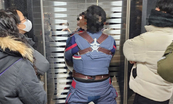 Ahn wearing Captain America's iconic costume blocks an elevator in the National Human Rights Commission of Korea's building in Jung District, central Seoul, on Feb. 10. [NEWS1]