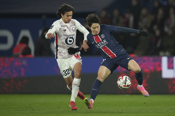Paris Saint-Germain midfielder Lee Kang-in, right, vies for the ball during a Ligue 1 match against Lille at Parc des Princes in Paris on March 1. [AP/YONHAP] 