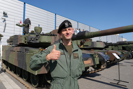 A Polish K2 tank operator gives a thumbs-up in front of a K2 tank on display at the 31st International Defence Industry Exhibition (MSPO) in Kielce, Poland, on Sept. 5, 2023. [KOREA DEFENSE INDUSTRY ASSOCIATION]