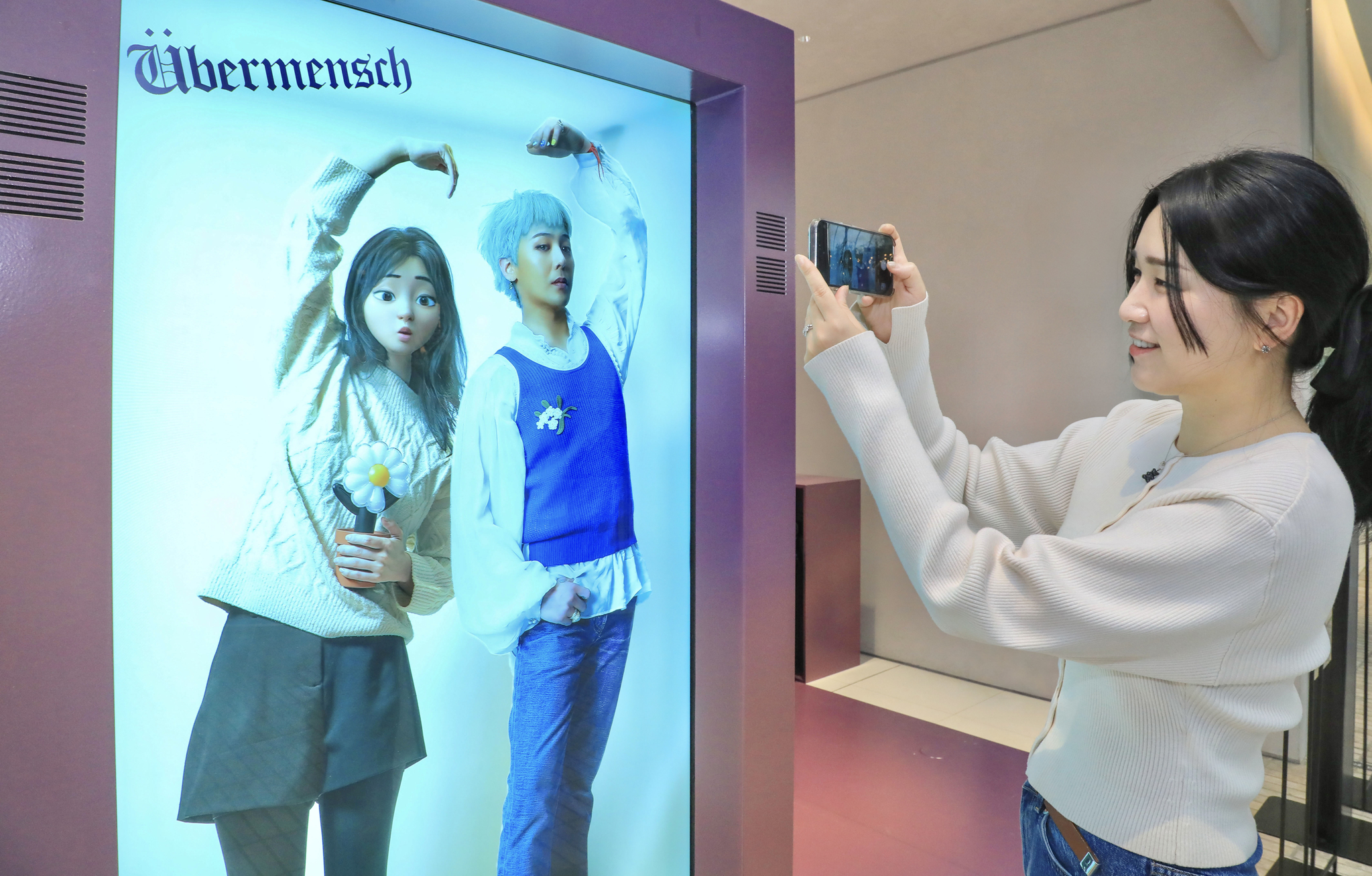 A visitor takes a picture of an immersive photo screen that allows visitors to take pictures with G-Dragon at the special media exhibition to celebrate album ″Übermensch,″ taking place from March 9 through March 19 at The Hyundai Seoul department store in western Seoul. [HYUNDAI DEPARTMENT STORE GROUP]