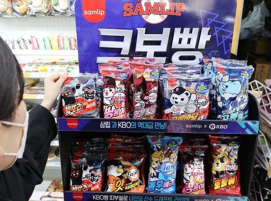 A shopper looks at KBO Bread, a collaboration between the KBO and SPC Samlip, in a convenience store on March 20. [YONHAP]