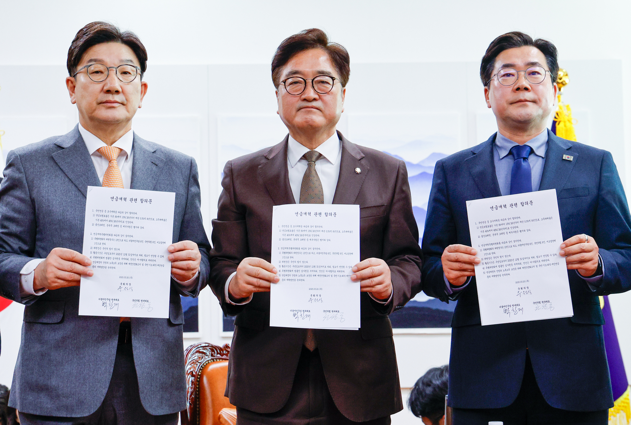Conservative People Power Party floor leader Kweon Seong-dong, left, National Assembly Speaker Woo Won-shik, center, and liberal Democratic Party floor leader Park Chan-dae hold documents listing agreed provisions for the National Pension Act at the National Assembly in western Seoul on March 20. [NEWS1] 