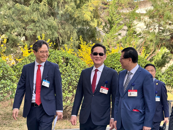 Samsung Electronics Executive Chairman Lee Jae-yong, center, converses with Lenovo Chairman Yang Yuanqing, right, in Beijing on March 23. Lee attended the opening ceremony of the two-day China Development Forum 2025 that day. [SHIN KYUNG-JIN]