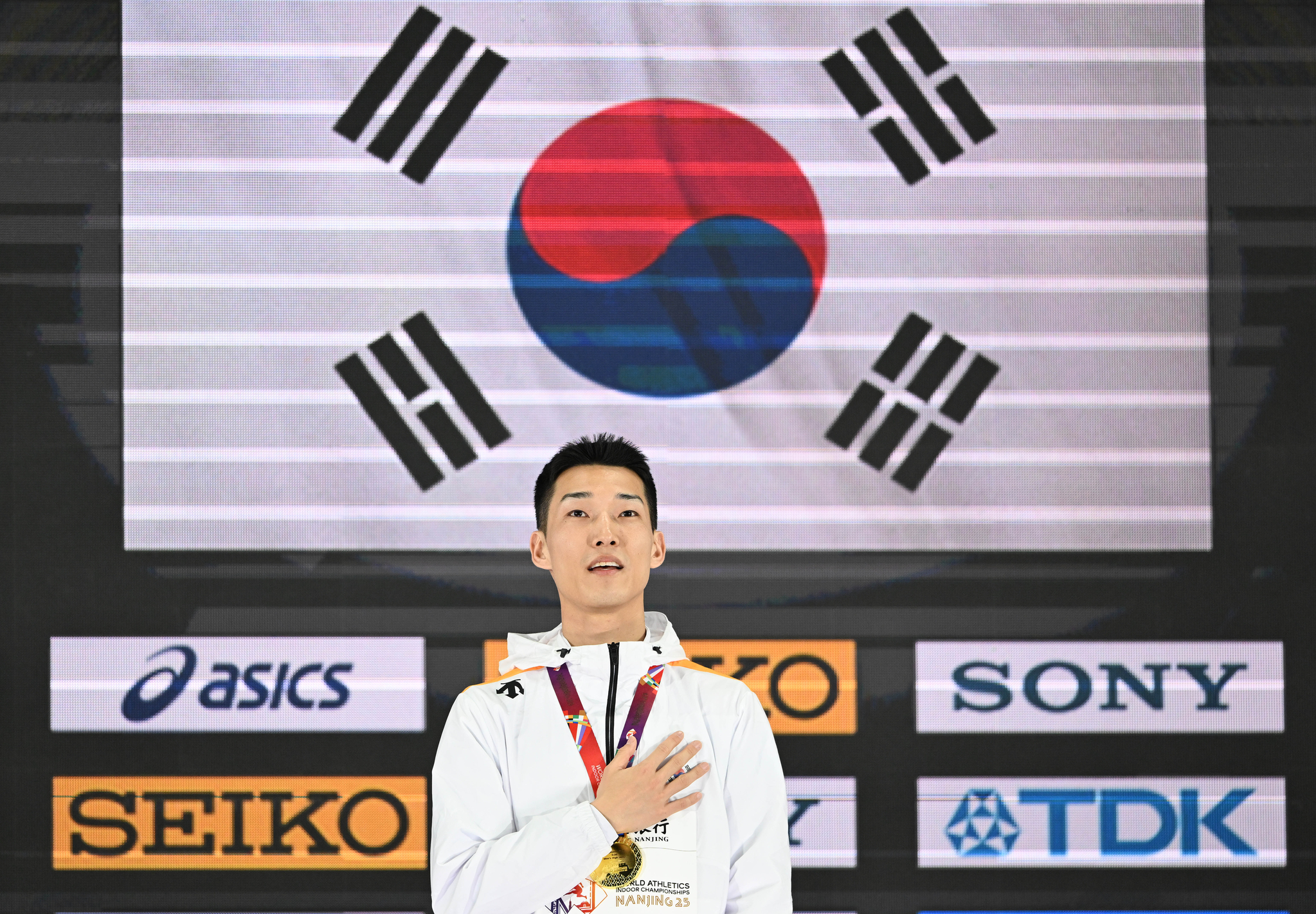 Woo Sang-hyeok stands during the national assembly on the podium at the Indoor World Athletics Championships in Nanjing, China on March 21.  [XINHUA/YONHAP]