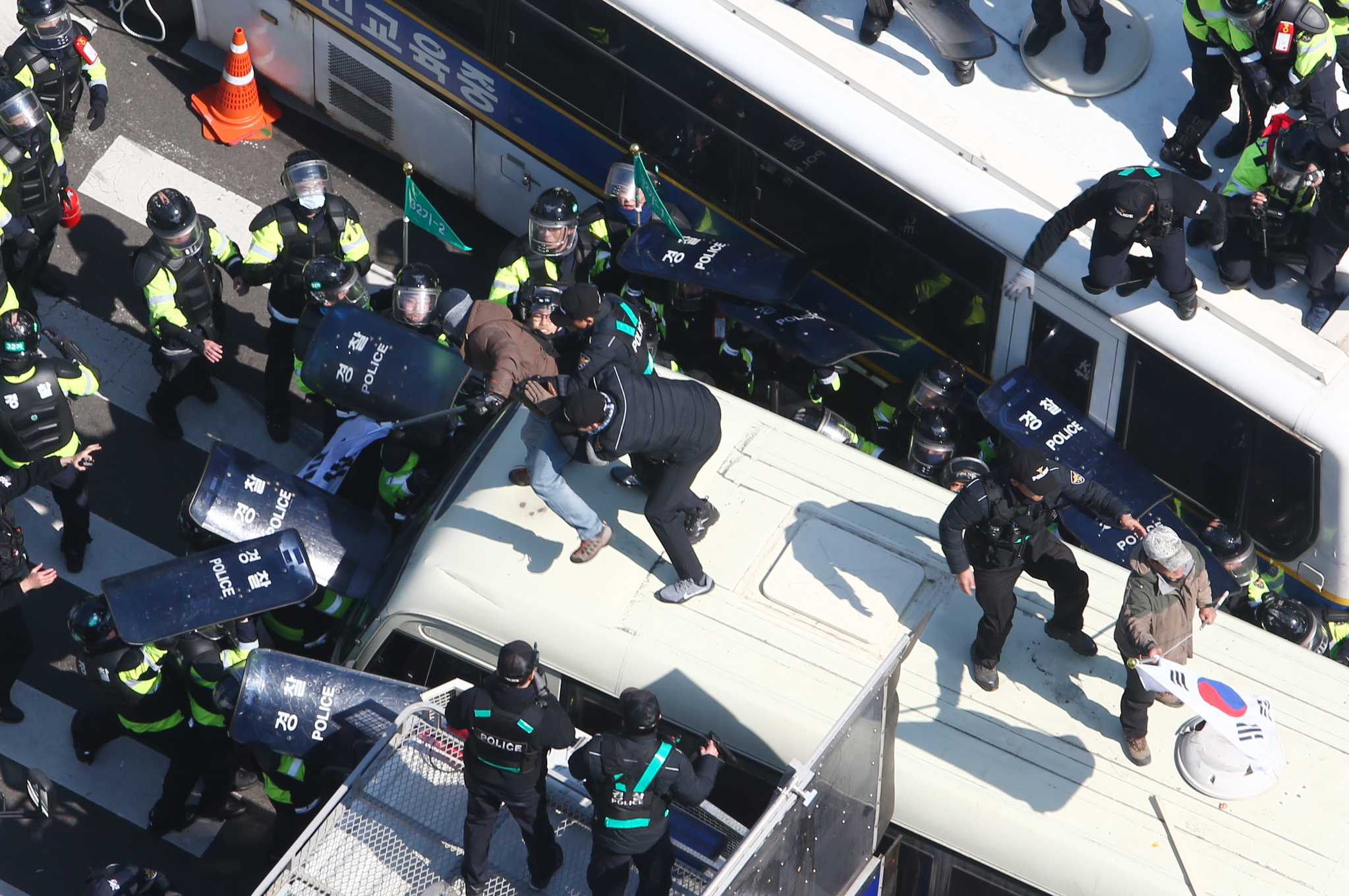 Police arrest protestor who climbed on top of police buses after the impeachment of former President Park Geun-hye was made official on March 10, 2017. [JOONGANG ILBO]