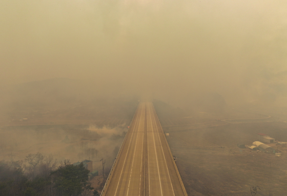 A section of road in Uiseong County, North Gyeongsang, remains closed on Monday, the third day wildfires have raged in the area. [YONHAP]