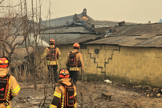Firefighters examine the scene as they extinguish a large wildfire in Goesan-ri in Uiseong County, North Gyeongsang, on March 22. [YONHAP]