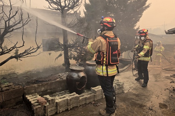 Firefighters extinguish a large wildfire in Goesan-ri in Uiseong County, North Gyeongsang, on March 22. [YONHAP]