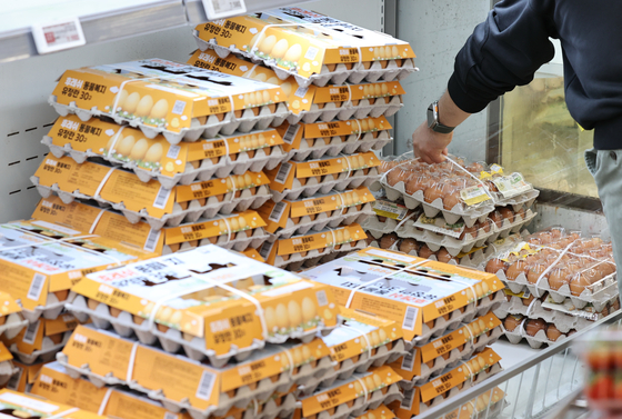 A shopper picks a pack of eggs at a supermarket in Seoul on March 24. [YONHAP]