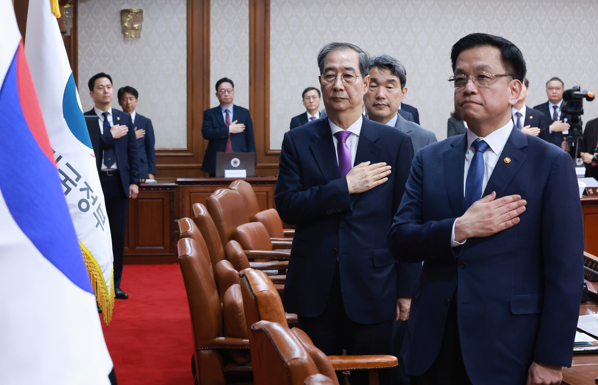 Acting President Han Duck-soo, center, Finance Minister Choi Sang-mok, right, and other ministers pledge allegiance to the Korean flag before a Cabinet meeting at the government complex in Jongno District, central Seoul, on March 25. [JOINT PRESS CORPS]
