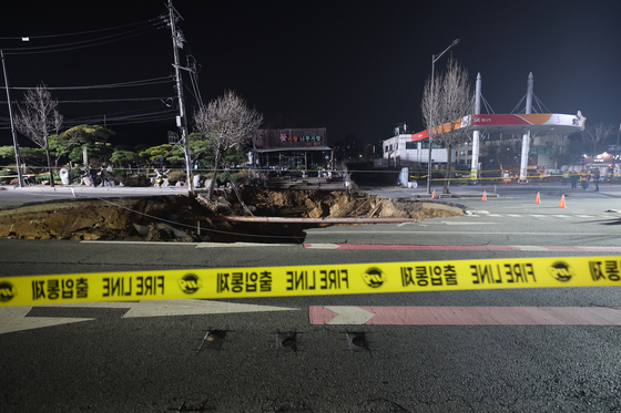 A large sinkhole is visible in a road in Gangdong District, eastern Seoul, on March 24. [NEWS1]