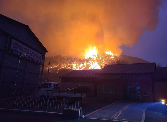 A wildfire continues to burn in Uiseong County, North Gyeongsang, on the night of March 24.  [YONHAP]