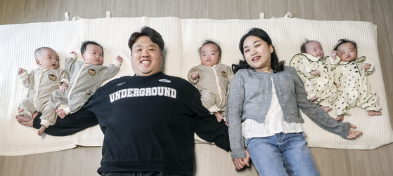 Kim Joon-yeong, left, and Sagong Hye-ran, parents of Korea's first naturally conceived quintuplets, pose for a photo with their five babies at their home in Dongducheon, Gyeonggi, on March 25. [KIM SEONG-RYONG] 
