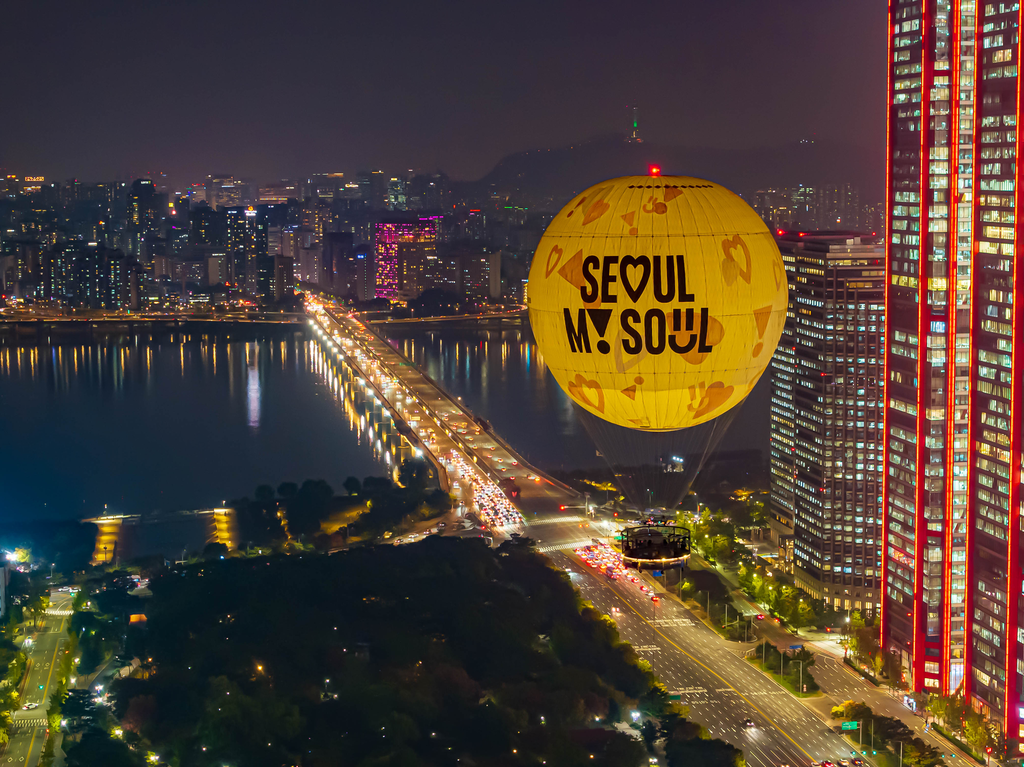 A moon-shaped tethered balloon Seouldal is seen in front of high-rise buildings while it floats above Yeouido Park in western Seoul. [SEOUL TOURISM ORGANIZATION] 