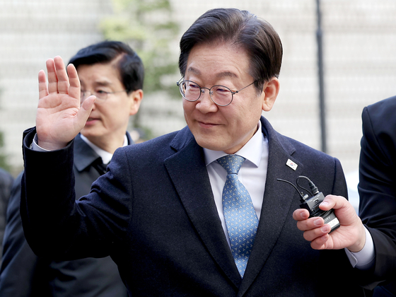 Democratic Party leader Lee Jae-myung waves to supporters as he heads into his second trial at the Seoul High Court in Seocho District, western Seoul, on Feb. 26. [YONHAP] 