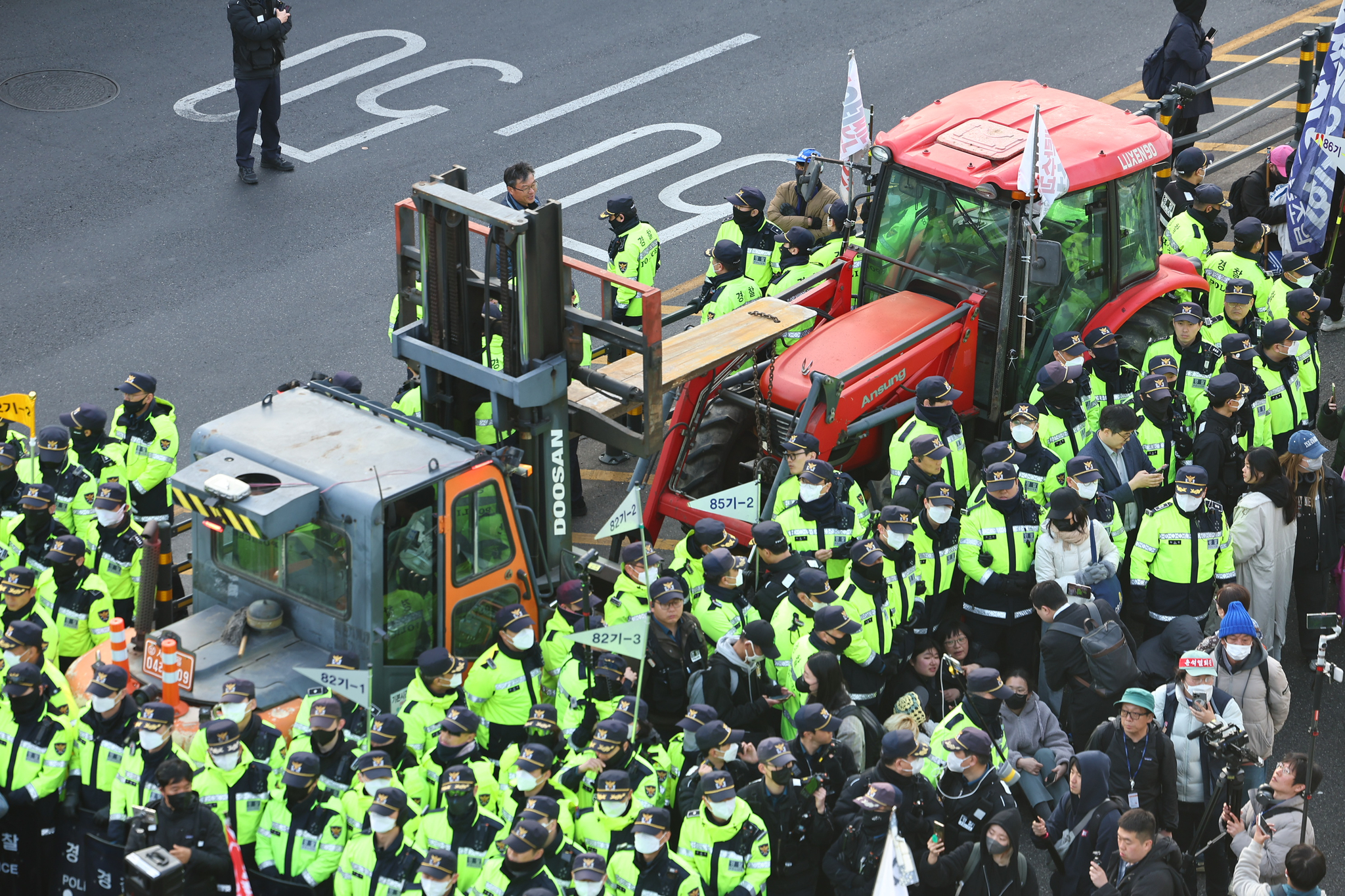 Police officers surround a tractor in Jongno District, central Seoul, on March 26. [YONHAP]