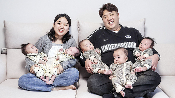 Sagong Hye-ran, left, and Kim Joon-yeong, parents of Korea's first naturally conceived quintuplets, hold their five babies and pose for a photo at their home in Dongducheon, Gyeonggi, on March 25. [KIM SEONG-RYONG] 