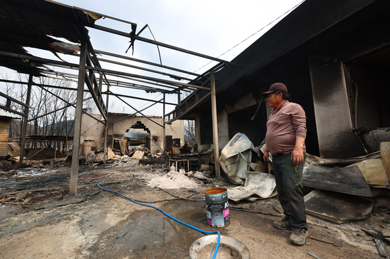 A man sees a destroyed garage in Uiseong County, North Gyeongsang, on March 27. His property was engulfed in a wildfire on March 26. [YONHAP] 