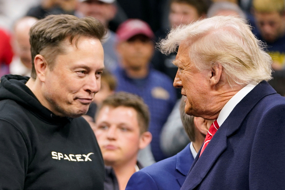 Tesla CEO Elon Musk greets U.S. President Donald Trump as they attend the NCAA men's wrestling championships in Philadelphia, Pennsylvania, March 22. [REUTERS]