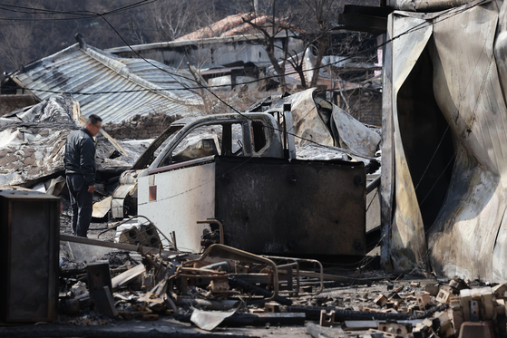 Wildfire victims and their families check the damage in a village in Andong, North Gyeongsang, on March 29. [YONHAP]