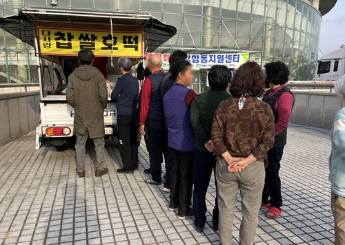 Street vendor Kim Min-jeong hands out hotteok, or Korean sweet pancakes, at Andong Gymnasium on March 31 to volunteers and evacuees affected by the wildfire that blazed through Andong, North Gyeongsang. [YONHAP]