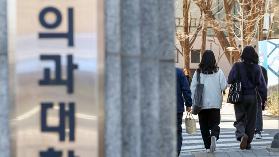 Students walk by a medical school gate in Seoul on March 28. [NEWS1]
