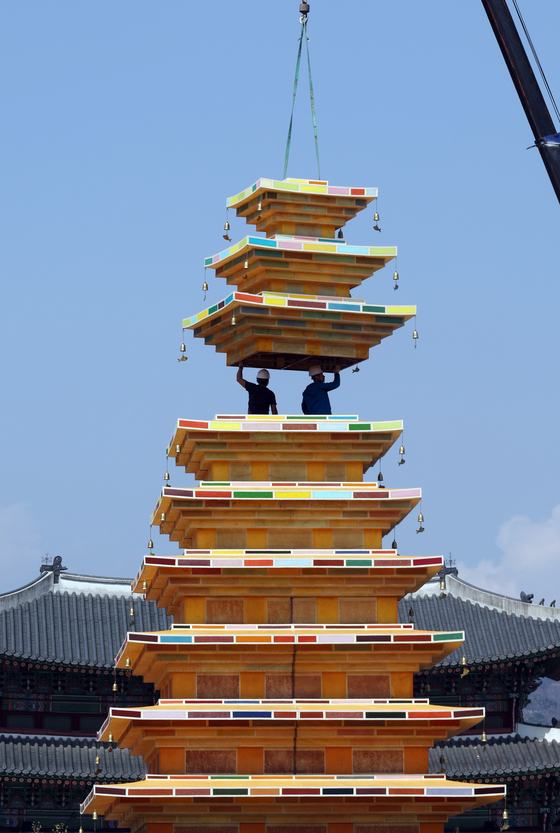 Workers install a monumental pagoda celebrating Buddha's birthday at Gwanghwamun Square in Jongno District, central Seoul, on March 31. [YONHAP]
