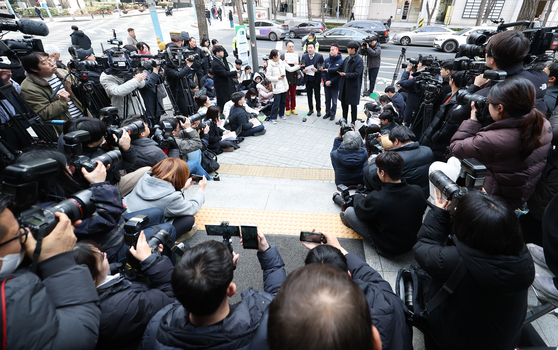 Attorney Bu Ji-seok of Law Firm Buyou, center, answers questions from reporters in front of the Seoul Metropolitan Police Agency in central Seoul on March 17, before reporting YouTuber Lee Jin-ho for defamation to the police. [NEWS1]