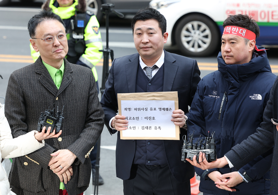 Attorney Bu Ji-seok of Law Firm Buyou, center, answers questions from reporters in front of the Seoul Metropolitan Police Agency in central Seoul on March 17, before reporting YouTuber Lee Jin-ho for defamation to the police. [NEWS1]